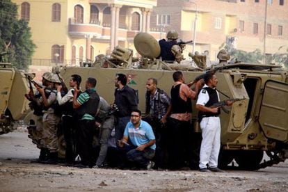 Las fuerzas de seguridad egipcias se protegen detrás de una tanqueta durante la intervención en Kerdasah.