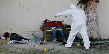 Forenses examinan  los cuerpos de dos jóvenes asesinados en Apodaca, a las afueras de Monterrey, México, el pasado 1 de diciembre.