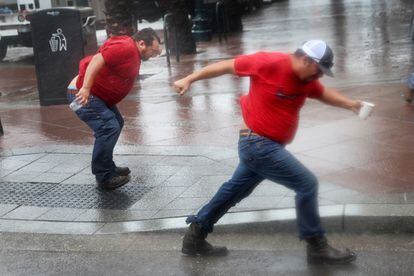 Dos trabajadores de la ciudad intentan caminar en el centro de Nueva Orleans.