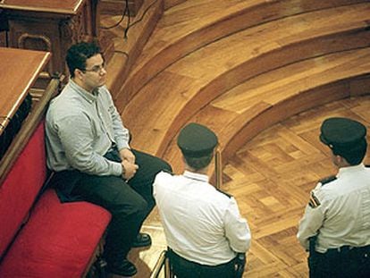 El acusado James Anglada, custodiado por dos policías, ayer, en la Audiencia de Barcelona.