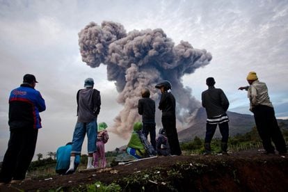 Las autoridades indonesias han ampliado este miércoles la zona de emergencia de cinco a siete kilómetros en torno al volcán Sinabug, tras varias erupciones que han lanzado una columna de ceniza y piedras volcánicas de varios kilómetros. En la imagen, un grupo de personas contempla la erupción en el distrito de Karo, al norte de la isla de Sumatra.