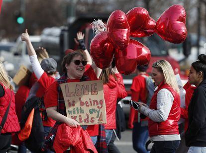 Anita Murano, maestra de la Escuela Primaria University Park, sostiene unnos globos durante una marcha hacia la sede de las Escuelas Públicas de Denver (EE UU), para entregar las tarjetas del Día de San Valentín, el 13 de febrero de 2019. Este grupo de maestros abandonó el trabajo el lunes 11 de febrero para dar inicio a la primera huelga de maestros en Denver en 25 años.