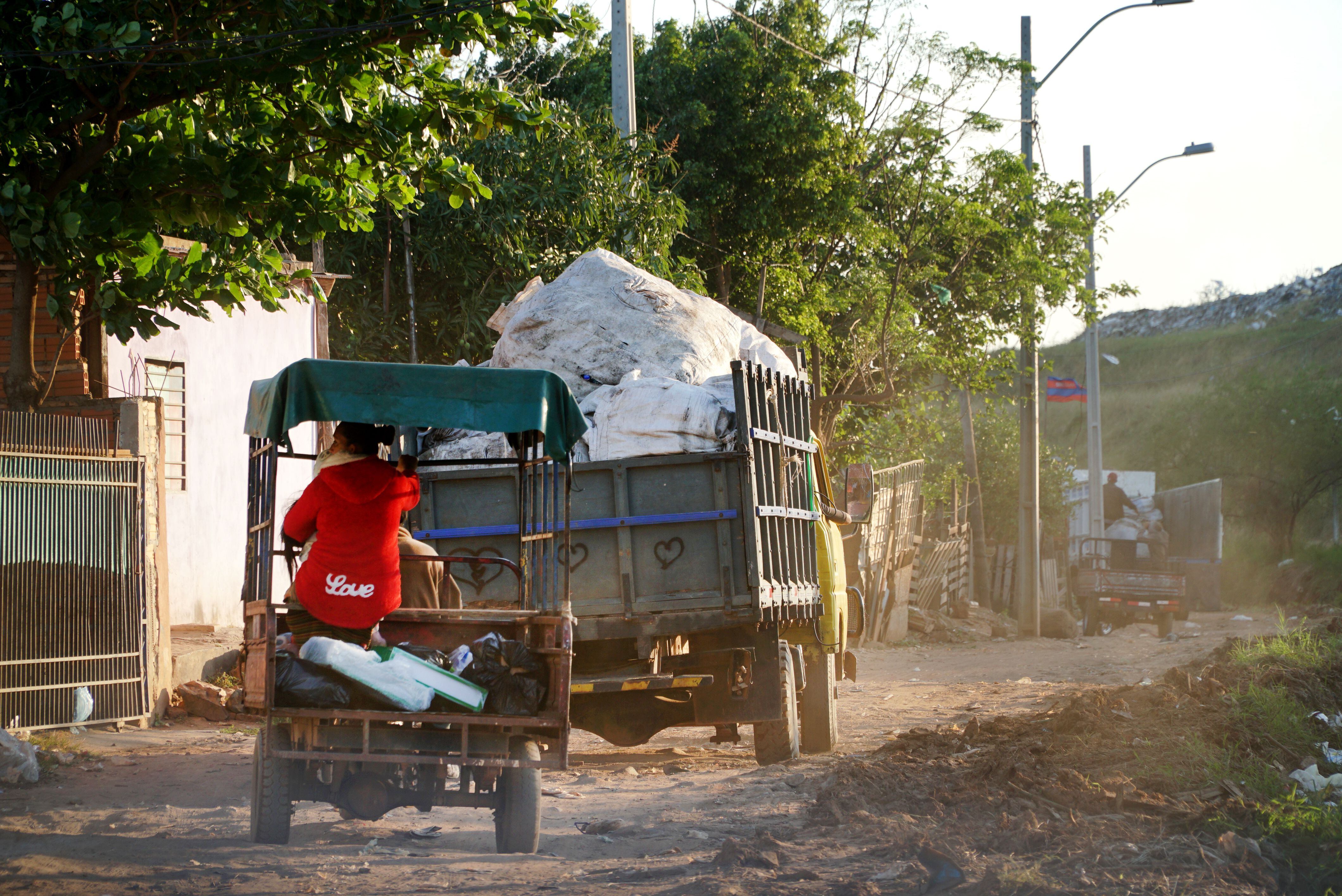 Camiones informales recogen y desplazan la basura en la capital de Paraguay.