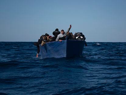 Un grupo de migrantes a bordo de una barca espera el rescate de la ONG española Open Arms en el Mediterráneo, en 2021.