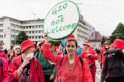 Una de las participantes de la protesta llamada "Color the Red Zone" sostiene un cartel que lee "G20 no es bienvenido".