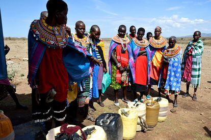 Un grupo de mujeres samburu aguarda para llenar bidones de agua en los nuevos grifos de la zona de Lpetpet, en el distrito de Samburu (Kenia). Gracias a ellos, las mujeres y niñas no tienen que emplear gran parte de su jornada en buscar agua y las familias no se ven obligadas a desplazarse para saciar la sed de su ganado.