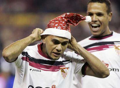 Alves se coloca un gorro de Navidad antes de ser felicitado por Luis Fabiano.