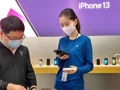 Una empleada de Apple atiende a un cliente en una tienda de la compañía en China.
