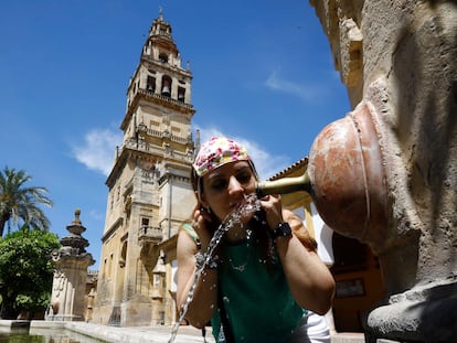 Una turista se refresca en la fuente del patio de los naranjos de la Mezquita-Catedral de Córdoba, este sábado.