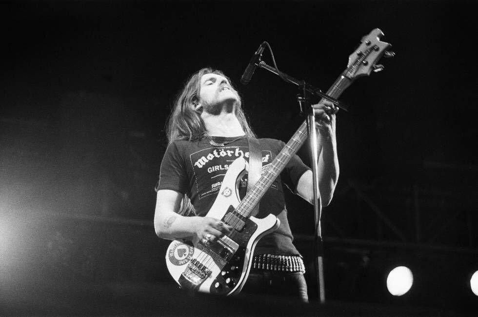 Lemmy Kilmister al frente de Motörhead tocando con su característica estética (con el micrófono más arriba de la cabeza y su gran bajo) en el festival inglés de Reading en 1979.