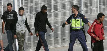 Un agente custodia a un grupo de inmigrantes en Algeciras