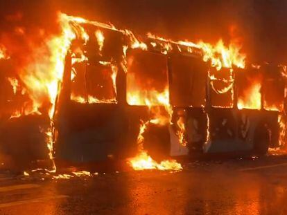 Un autobús arde en llamas a las afueras del Liceo de Aplicación, en Santiago, este jueves, en una imagen compartida en redes sociales.