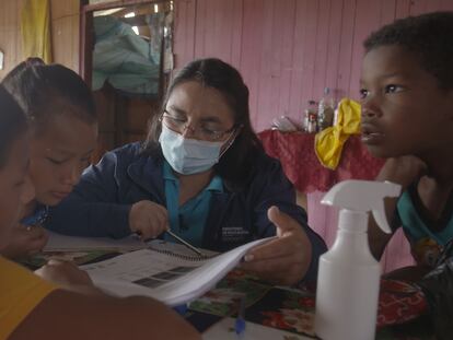 Adriana López da clase a Michelle en presencia de sus hermanos en Cascales (Sucumbíos, Ecuador).