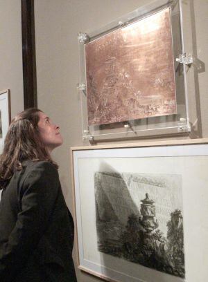 Una mujer contempla la plancha de cobre de Piranesi que se exhibe en la pìnacoteca bilbaína.