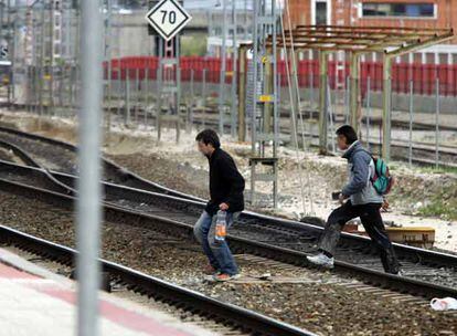 Dos toxicómanos cruzan las vías de la estación de San Cristóbal Industrial.