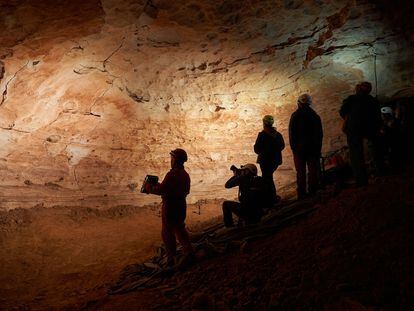 Investigadores del Instituto Catalán de Paleoecología Humana y Evolución Social (IPHES) ante las pinturas rupestres prehistóricos de la Cueva de la Villa.