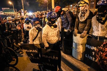 Los manifestantes sostienen escudos improvisados ​​del grupo de "mamás de primera línea", durante una nueva protesta contra el gobierno del presidente Iván Duque, al sur de Bogotá, el 22 de mayo de 2021.