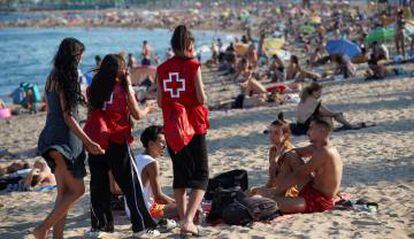 Miembros de la Cruz Roja participan en una campaña puesta en marcha porl la Generalitat para sensibilizar a los jóvenes para disminuir el riesgo de contagio.