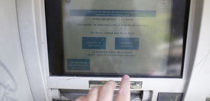 Información sobre la comisión de dos euros en cajero automático en una oficina bancaria de CaixaBank.