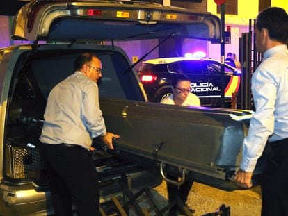 Trabajadores de la funeraria trasladan el cadáver de la mujer asesinada en Granada.