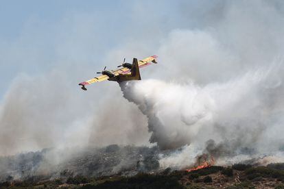 Un avión canadair arroja agua sobre el incendio forestal declarado cerca de la ciudad de Volos. 