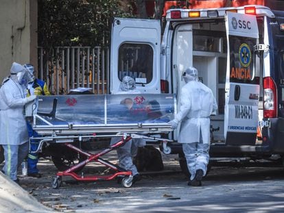 Personal sanitario traslada al hospital a un paciente con covid-19, este domingo, en Ciudad de México.