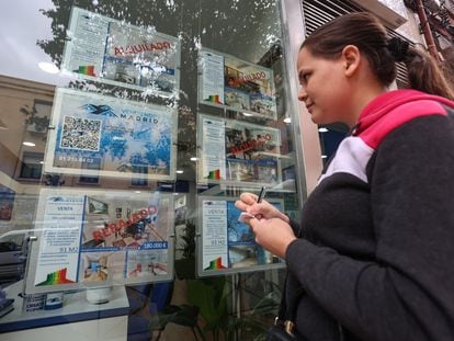 Una mujer apunta en una libreta los pisos en alquiler de una inmobiliaria madrileña.
