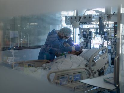 Un sanitario asiste a un enfermo de covid-19 en el Hospital Clinic de Barcelona, en diciembre de 2021.