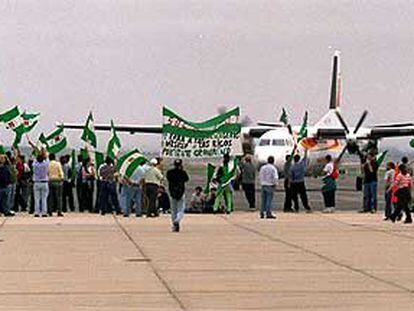 Jornaleros del SOC, ayer en la pista del aeropuerto de Sevilla.