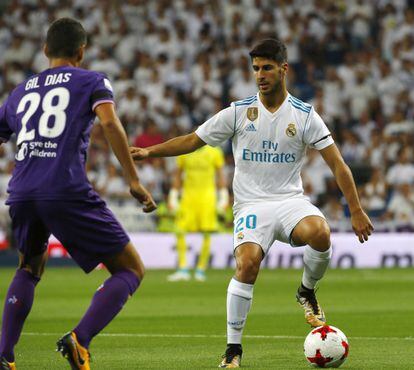 El delantero del Real Madrid Marco Asensio (d) controla el balón junto a Gil Dias, de la Fiorentina.