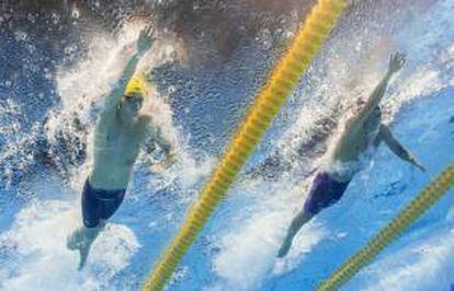 El nadador australiano Thomas Fraser-Holmes (i) y el japonés Kosuke Hagino compiten en una de las series eliminatorias de la prueba de 200M libres masculinos de los Campeonatos del Mundo de Natación hoy, en la piscina del Palau Sant Jordi de Barcelona (España).