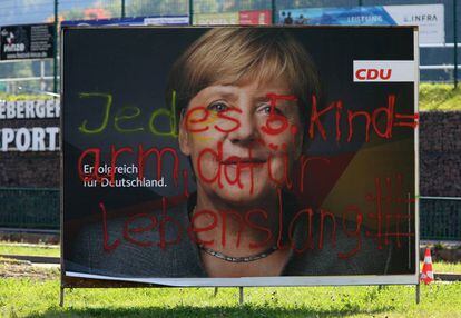 Pintada antiinmigrantes en un cartel electoral de Angela Merkel.