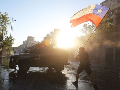 Un manifestante ondea una bandera chilena, este viernes en una protesta en vísperas del plebiscito constitucional.