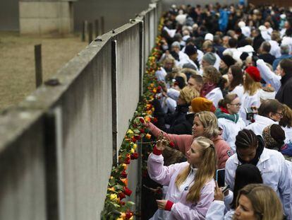 Uma multidão coloca flores no Memorial do Muro, neste sábado.