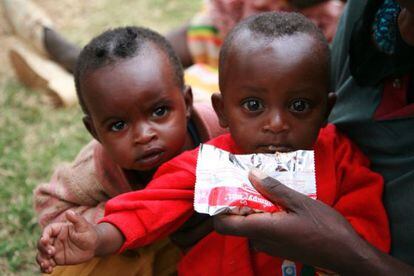 Niños etíopes reciben una ración de alimento en bolsas.