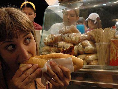 Una joven sacia el apetito en uno de los tradicionales puestos de comida de las fiestas de la Paloma.