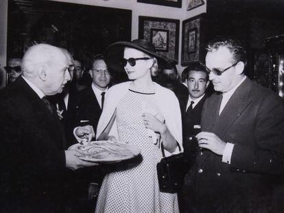 Grace Kelly y Rainiero Grimaldi observan el plato que muestra González Martí, en el Museo Nacional de Cerámica.