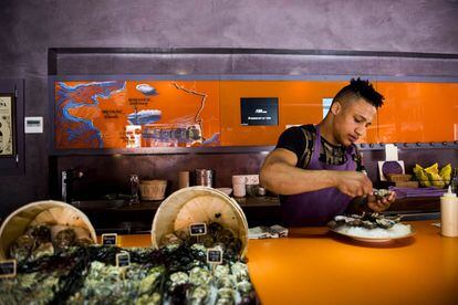 Uno de los camareros del restaurante Le Gouthier preparando un plato de ostras, la especialidad de la casa.