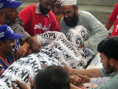 Un grupo de paquistan&iacute;es portan el cuerpo del candidato asesinado este viernes, Sadiq Zaman Khattak.