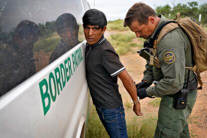 Un agente de la Patrulla Fronteriza estadounidense quita las esposas a un migrante detenido para que éste sea transportado, el pasado 8 de septiembre, cerca de Sasabe, Arizona (EE UU).