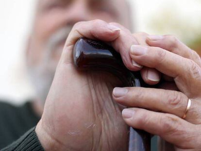 Un anciano con bastón, apoyado en una barandilla en Madrid.