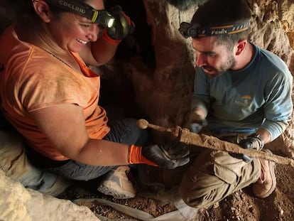 Dos arqueólogos extraen una de las cuatro espadas romanas halladas en Israel.