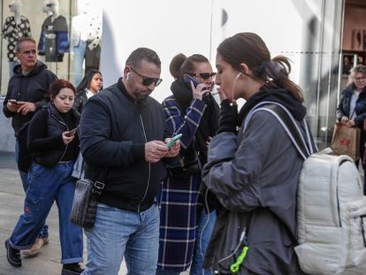 Usuarios de telefonía móvil en la Gran Vía de Madrid.