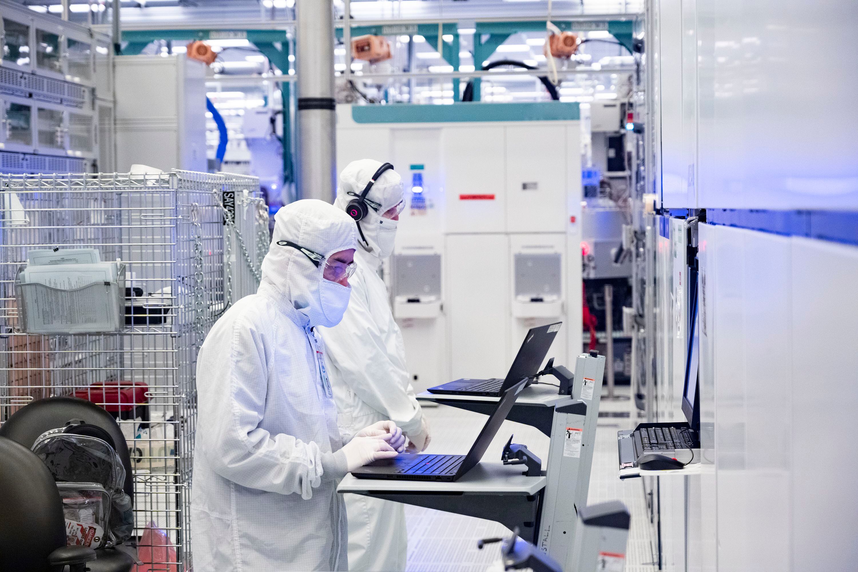 Dos empleados trabajan en la sala limpia de la fábrica de chips de Intel en Hillsboro, Oregon.
