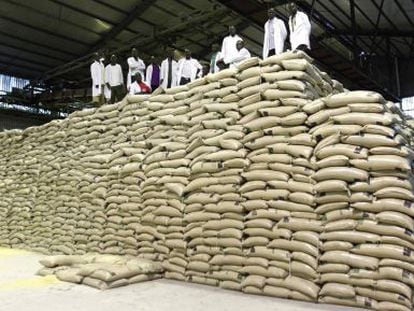 Trabajadores sobre sacos de azúcar en una planta de Kenia.