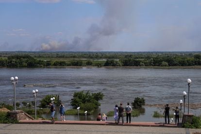 Varias personas observan el río Dniéper a su paso por Jersón, este martes.