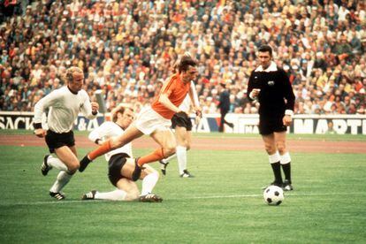 Johan Cruyff supera una entrada de Uli Hoeness d'Alemanya Occidental durant la final del Mundial de 1974. A l'esquerra, el jugador alemany Vogts.