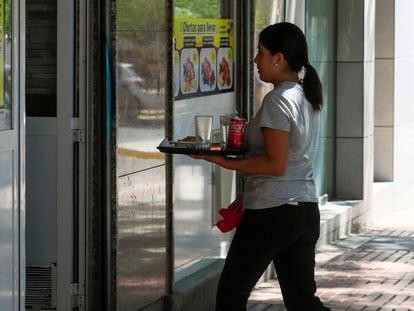Una camarera retira un servicio en una cafetería de Madrid.