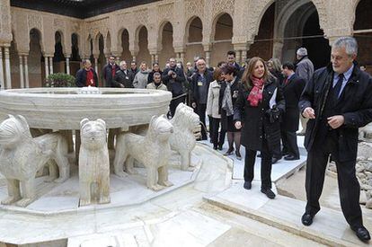 El presidente de la Junta de Andalucía, José Antonio Griñán y la directora del Patronato de la Alhambra, María del Mar Villafranca, observan el aspecto de la renovada fuente de los Leones.