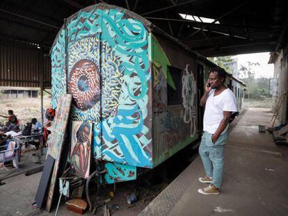 Varios artistas del colectivo BSQ trabajan frente a un vagón de tren abandonado y convertido en estudio de arte en el centro de Nairobi, Kenia, el 20 de agosto de 2019.